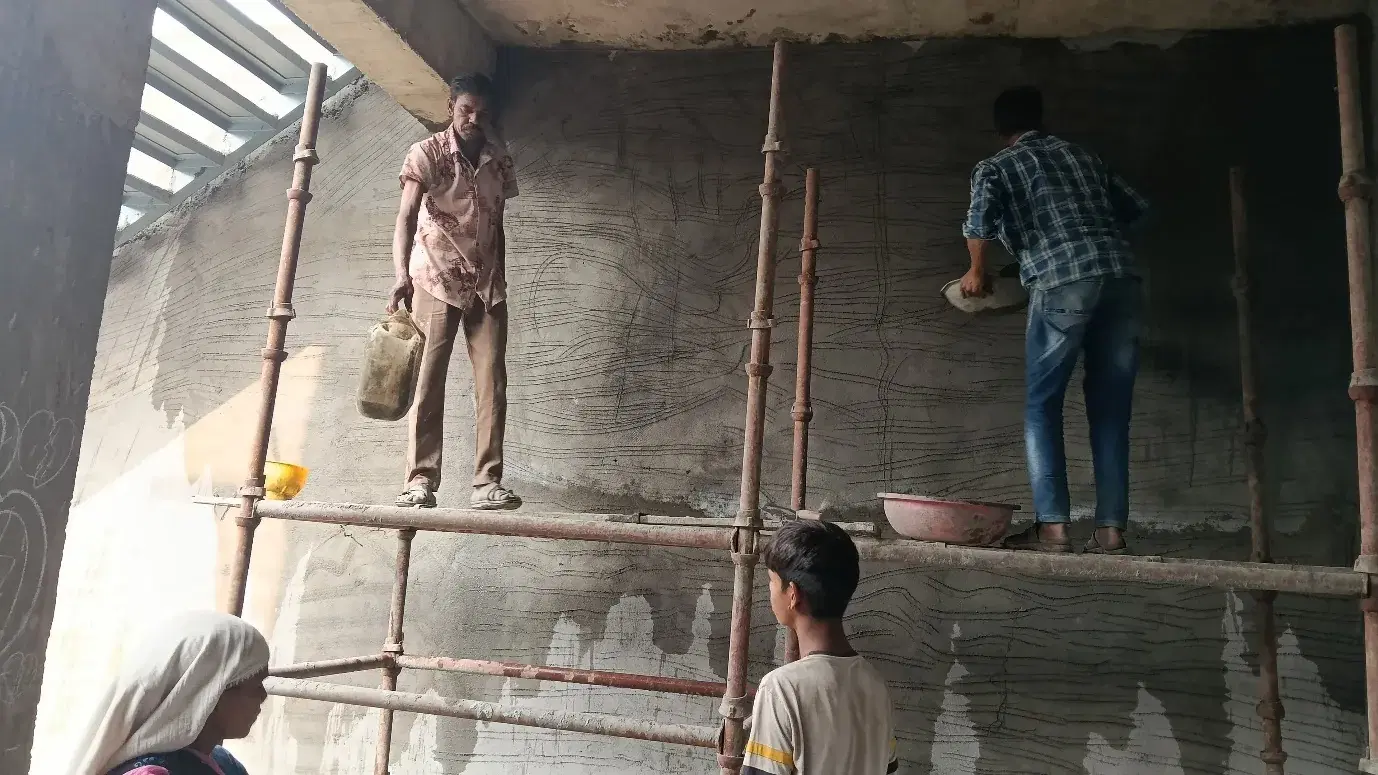 Workers plastering an interior wall at Gujarat Fluorochemicals