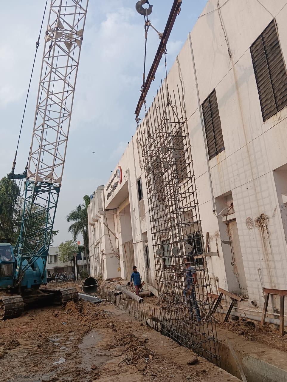 Crane lifting reinforcement beside the hospital building